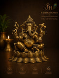 A brass Ganesha statue displayed on a dark brown background with a lit candle and a plant in the background. The image includes branding text for 'Yashrahomes' and feature icons for premium brass, innovative design, artisan crafted, and timeless elegance.
